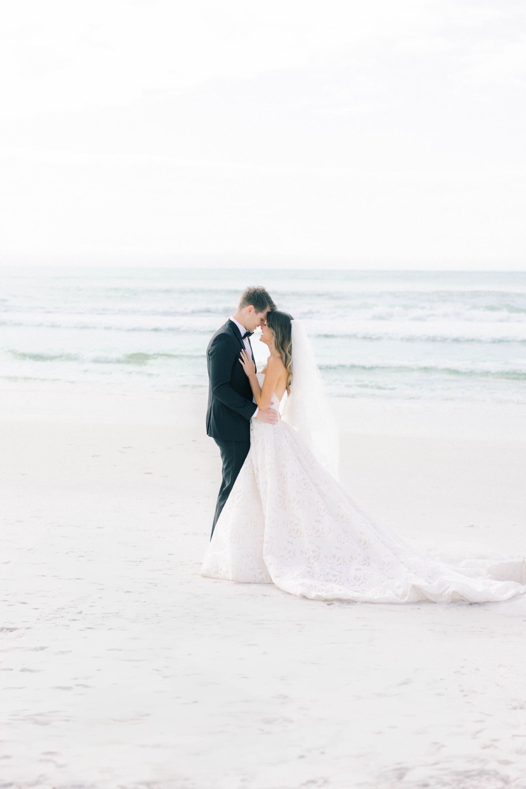 Couple on Seaside beach taking wedding portraits forehead to forehead