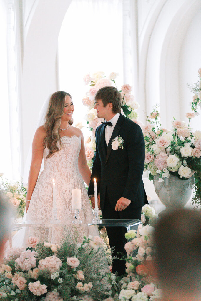 Bride and groom at the altar surrounded by blush florals during their Schimmel Ballroom ceremony at The Kimpton Cottonwood