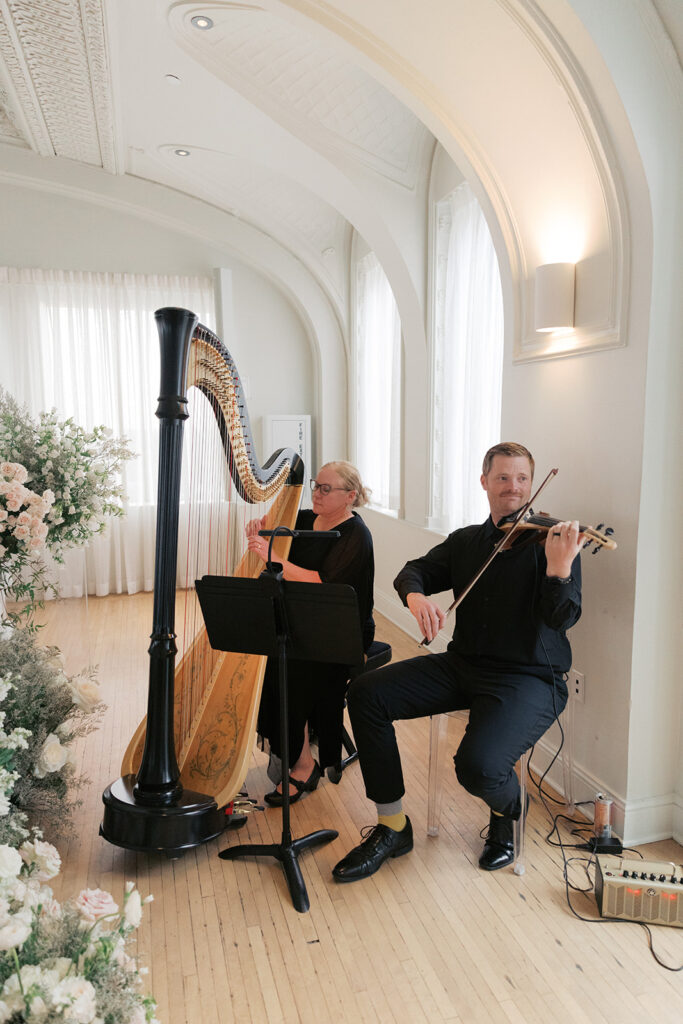 Harpist and violinist playing the wedding ceremony in the Schimmel Ballroom at The Kimpton Cottonwood, Omaha