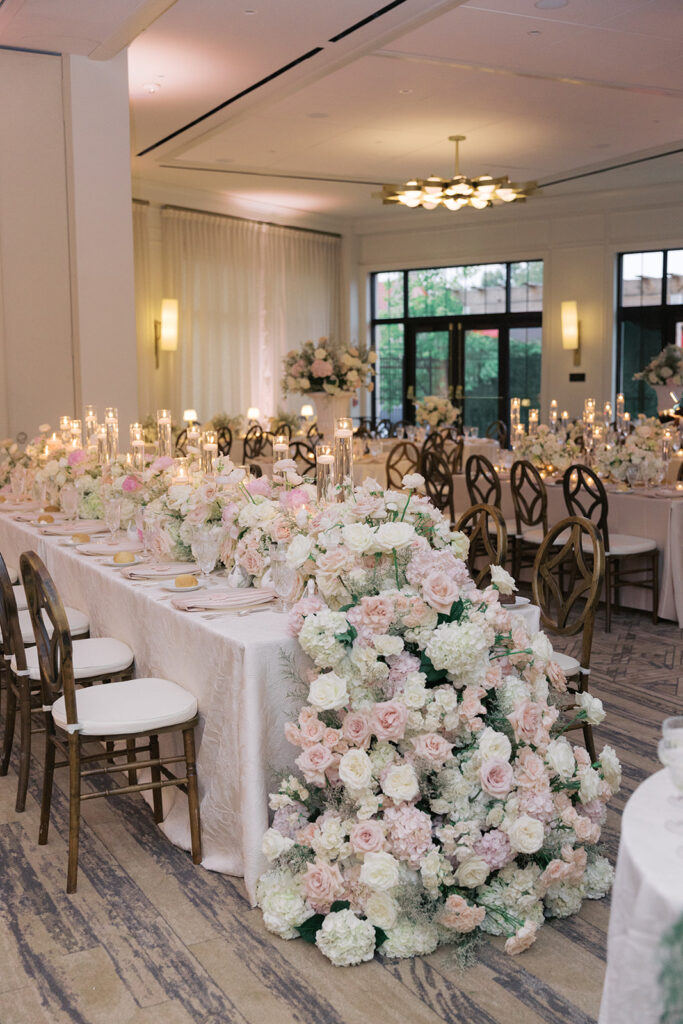 Candlelit dinner tablescape with abundant blush florals in the Gold Coast Ballroom at The Kimpton Cottonwood
