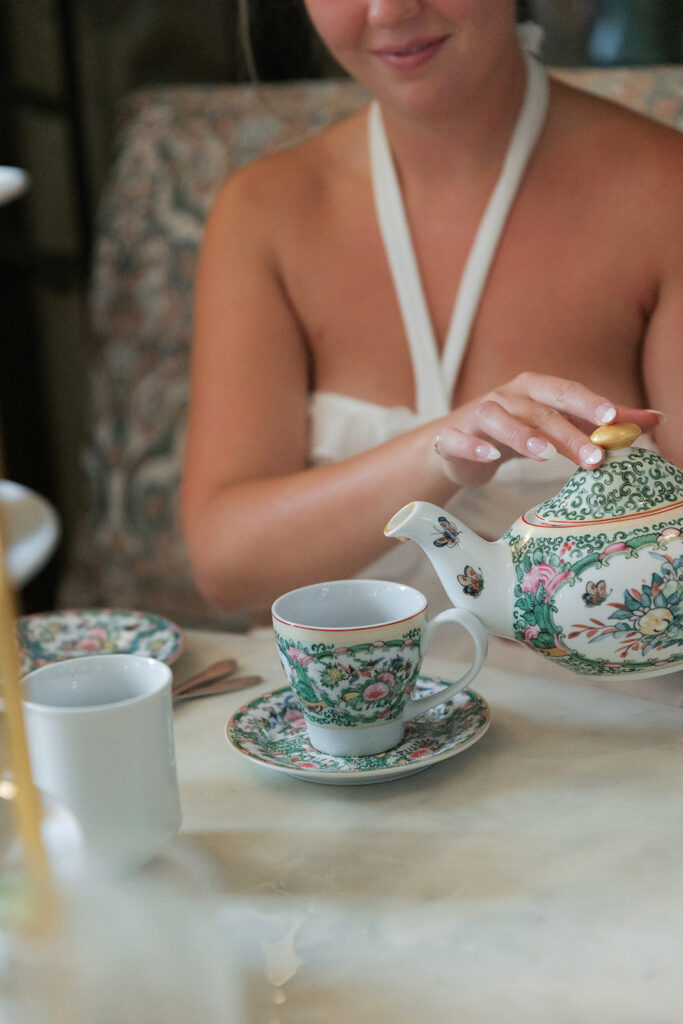 Pouring tea from a floral teapot at a day-after wedding brunch in the Tea Room at The Kimpton Cottonwood