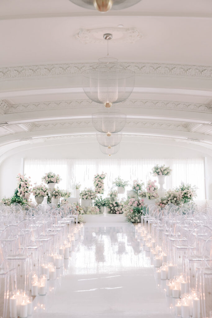 Ceremony setup with blush florals and a candlelit aisle in the Schimmel Ballroom at The Kimpton Cottonwood, Omaha